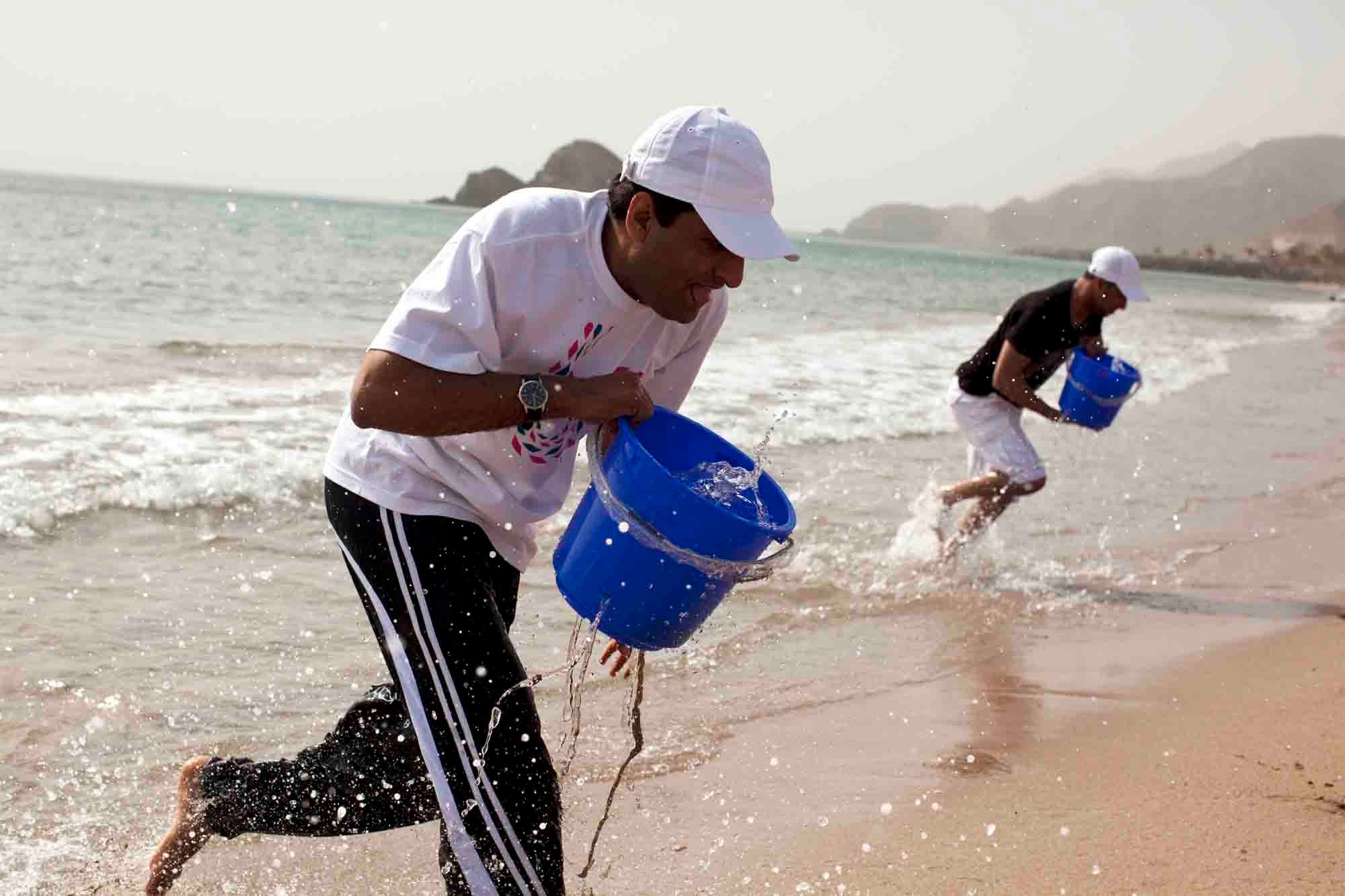 Corporate team building activity in Dubai with employees participating in a beach clean-up CSR program